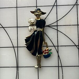 Figure holding dog and basket brooch